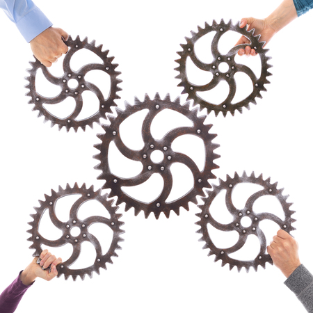Many different hands hold gears that mesh. Group dynamics and successful teamwork, business conceptの写真素材