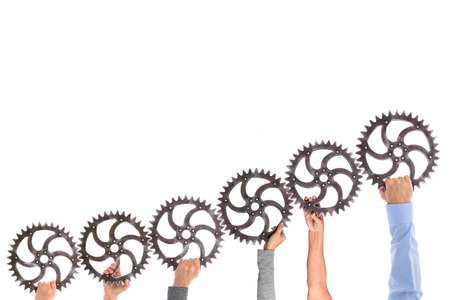 Many different hands hold gears that mesh. Group dynamics and successful teamwork, business conceptの写真素材