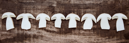 Flatlay, Boletus Edulis slices on wooden Table, fresh and raw Porcini Mushroomsの写真素材