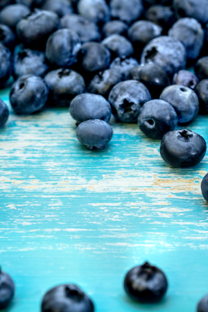 fresh Blueberries or huckleberries on blue wooden table with copyspaceの写真素材