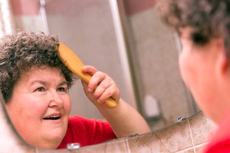 a mentally disabled woman combing through her hairの写真素材