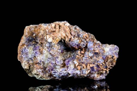 Raw fluorite or fluorspar mineral stone in front of black background, mineralogy and esotericism