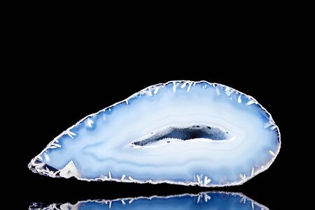 Raw blue agate mineral stone in front of black background, mineralogy and esotericismの写真素材