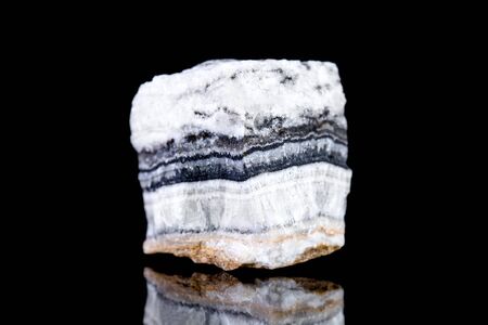 Raw white calcite mineral stone in front of black background, mineralogy and esotericismの写真素材