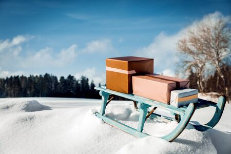 Gifts on a shabby chick sledge in front of snowy wintertime landscape, concept christmasの写真素材