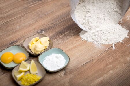ingredients for a homemade cookie dough or cake, flour on the wooden tableの写真素材