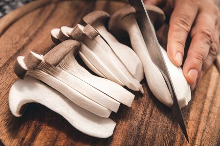 Cutting slices of king oyter mushrooms, fresh raw Pleurotus eryngii fungi, closeupの写真素材