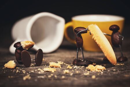 coffee bean figures with cookies or biscuits are having a coffee break on a wooden rustic table