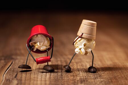 two funny popcorn figures are doing a walk, wearing buckets as caps, wooden table and black...