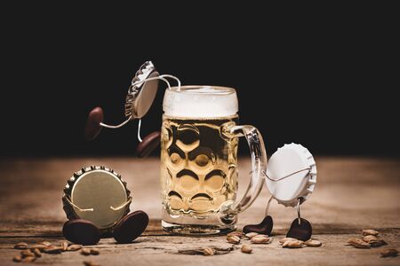 Crown cork miniature figures with barley and beer glass, humorous conceptual scene for a pup or...