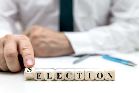 businessman or election worker changes the word election to selection, concept election in the usaの写真素材