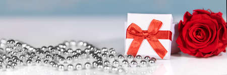 banner with Gift box and red ribbon, rose and silver chaplet, Mother's day or valentine's day backgroundの写真素材