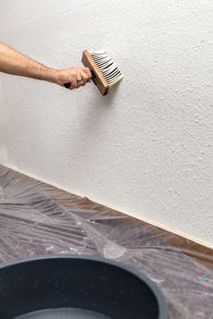 The wallpaper is soaked with a brush and water before removingの写真素材