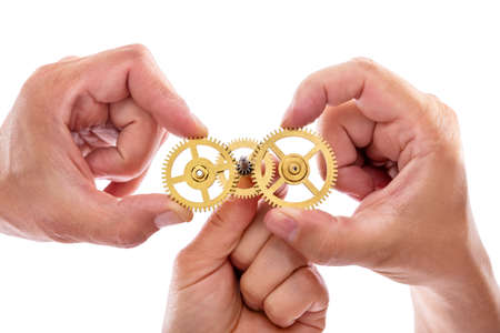 group of hands are holding cogwheels, working together, concept teamwork and engineeringの写真素材