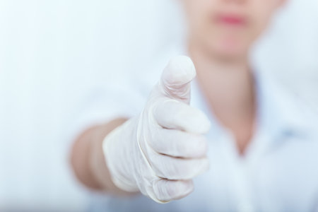 Female nurse or doctor is holding the hand for a handshake to the viewer. professional caregiver or doctor in her officeの写真素材