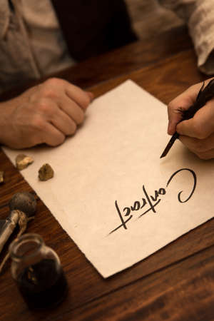 Closeup, Man sign a contract with a quill and ink, concept business in the medievalの写真素材