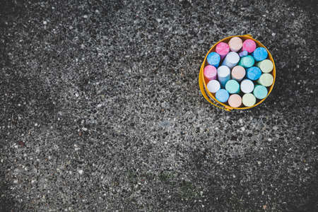 a bucket full of colorful street chalk, copyspace at the left