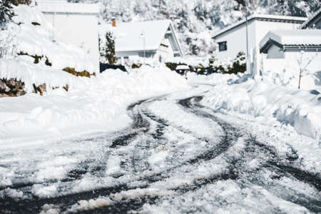 Snow chaos on the street, village covered with snow at winter season, black ice and snowpocalypseの写真素材