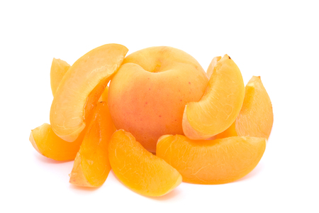Whole apricot surrounded by apricot slices on white backgroundの写真素材
