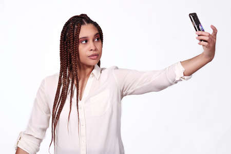 attractive woman taking selfie on white background