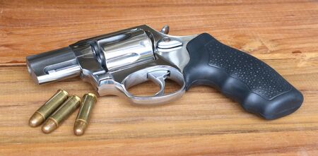 Gun placed on a table with bullet shells