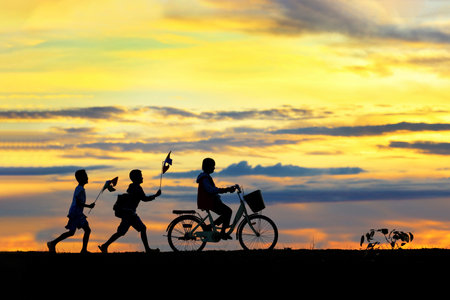 Silhouettes of children running around funny in the morning.の写真素材