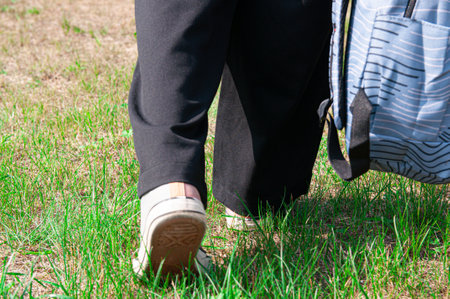 close-up student going on grass with her backpack