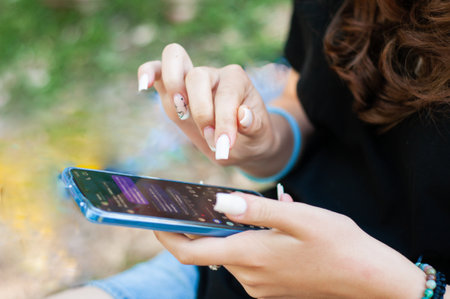 Close up girl with long nails typing in phone