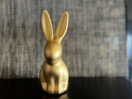 Golden bunny figurine with blured background, perfect for Easter, copy space.の写真素材
