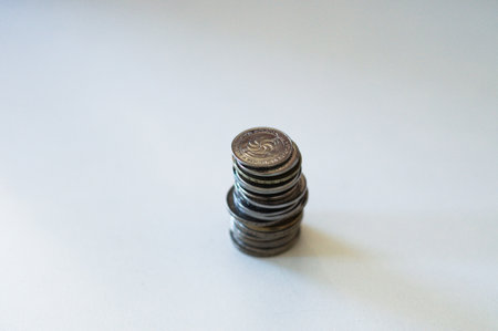 Stack of coins on a plain surface, symbolizing financial savings or economy.