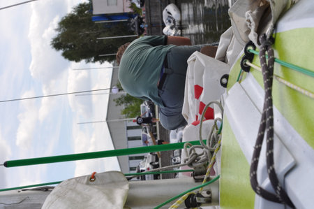 Man on a sailing boat, enjoying a summer day on the waterの写真素材