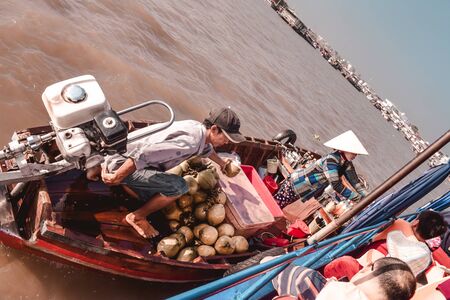 Boat selling coconuts to tourists in the Can Tho floating market in Saigon South Vietnamの写真素材