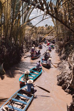 Rowing boats with tourists flowing down mangroves at Mekong Delta in Vietnam