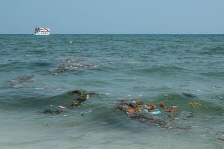 A boat on a polluted sea full of trash in China Asiaの写真素材