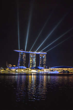 Evening lights show at Marina Bay Sands Hotel in Singapore reflected in the water of the Bay