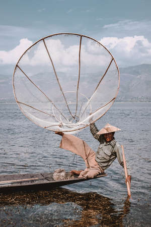 Traditional Fisherman at Inle Lake in Myanmar Barma posing in a lying posture for touristsのeditorial素材