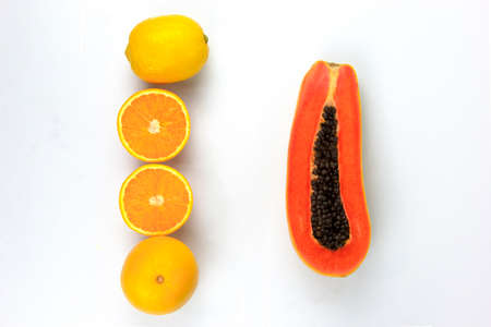 Arranging Oranges in line and papaya sliced with isolated on white background, placed in the center of background, used in food and smoothie conceptsの写真素材