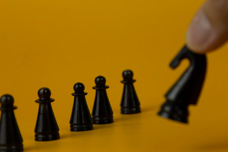A black horse Chess standing for facing to the team and fighting the problem on business on  isolated yellow background, used for successの写真素材