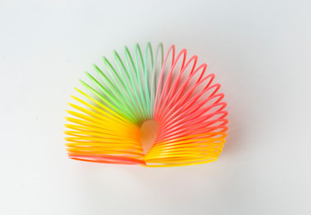 A colorful Rainbow for kid toy on isolated background, A rainbow color toy, A Rainbow colored wire spiral toy on white backgroundの写真素材