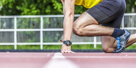 Young male runner taking ready to start position