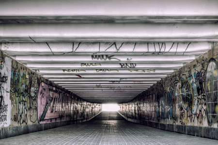 Old underground tunnel with modern creative graffitiの写真素材