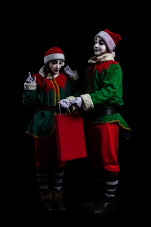 Couple of elf mimes in New Year costumes isolated on black backgroundの写真素材