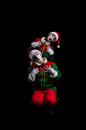 Couple of mimes in New Year costumes posing isolated on black backgroundの写真素材