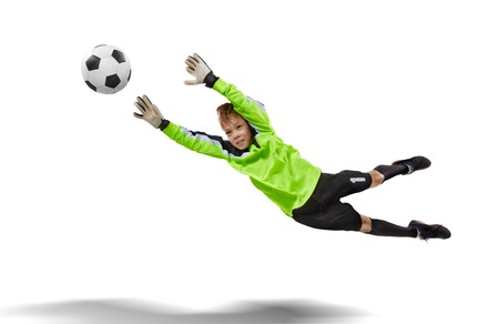 goalkeeper kid flying for the ball isolated on whiteの写真素材