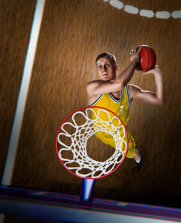 basketball player making slam dunk on basketball arenaの写真素材