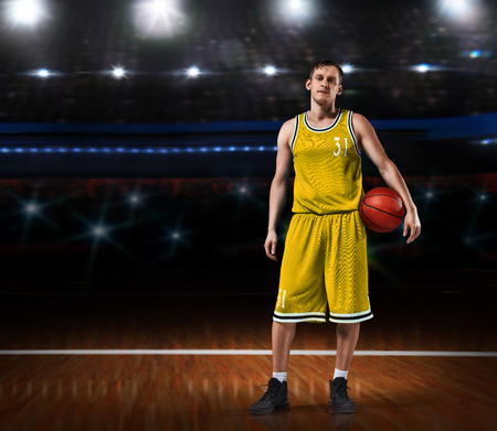 basketball player in yellow uniform standing on basketball courtの写真素材
