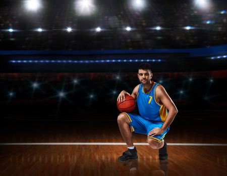 basketball player in blue uniform sitting on basketball courtの写真素材