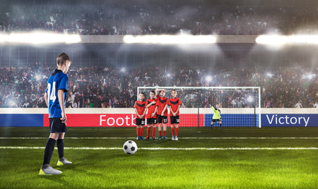 kid football player prepairing to take a shot on a football fieldの写真素材