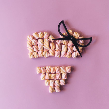 Valentines heart made of rainbow colored sweets on a soft purpleの写真素材