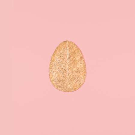 Golden Eastern egg made of single leaf painted in gold. Flat lay minimal Eastern composition.の写真素材